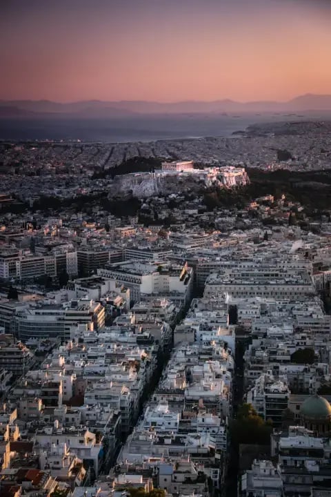 Athens cityscape with the Acropolis overlooking surrounding homes at sunset